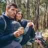 Hikers resting in forest eating sandwiches during a long hike