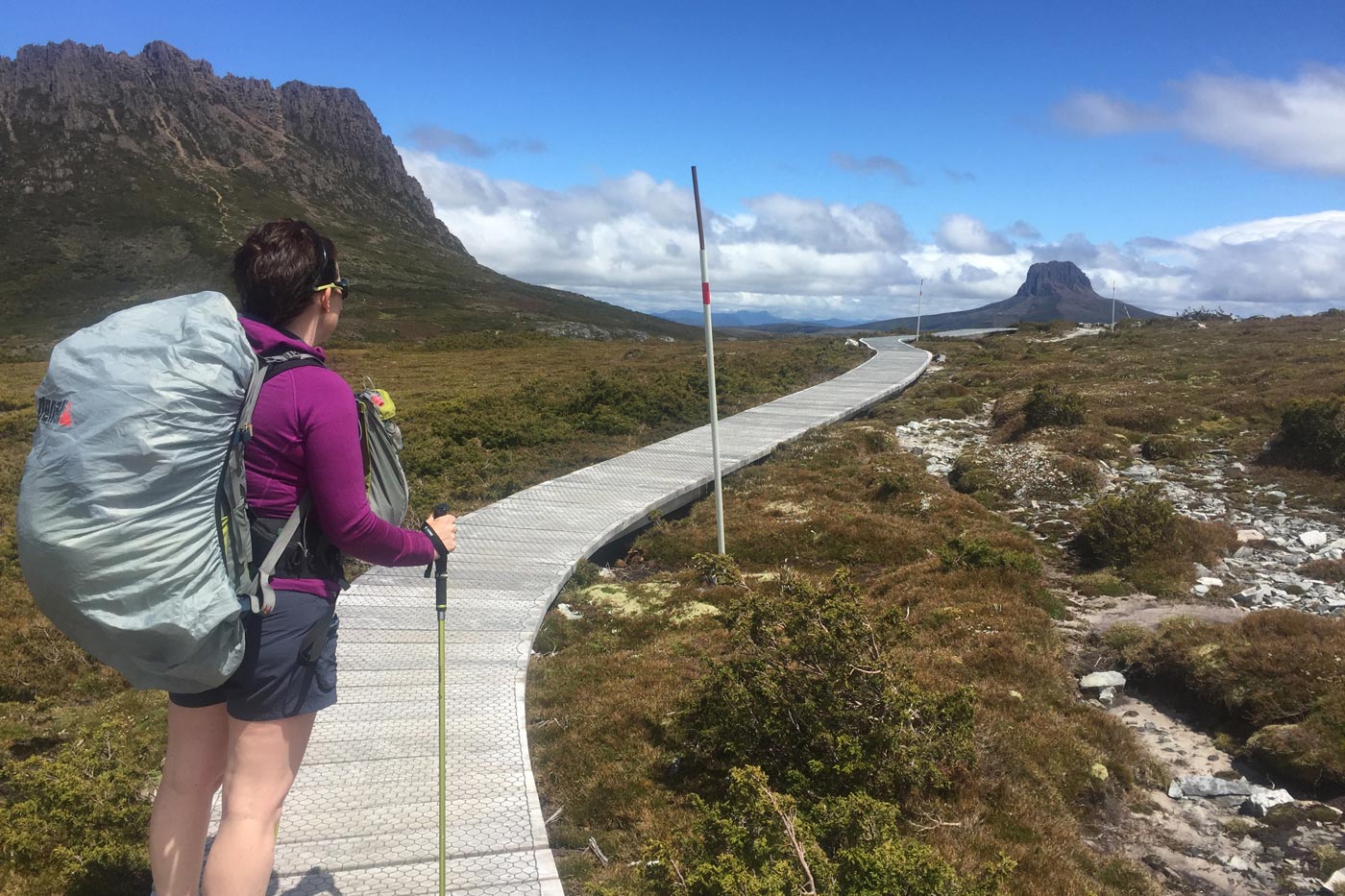 A hiking trail winding through bushland toward distant hills, with the path clearly guiding the viewer’s eye through the image, illustrating leading lines in landscape photography.