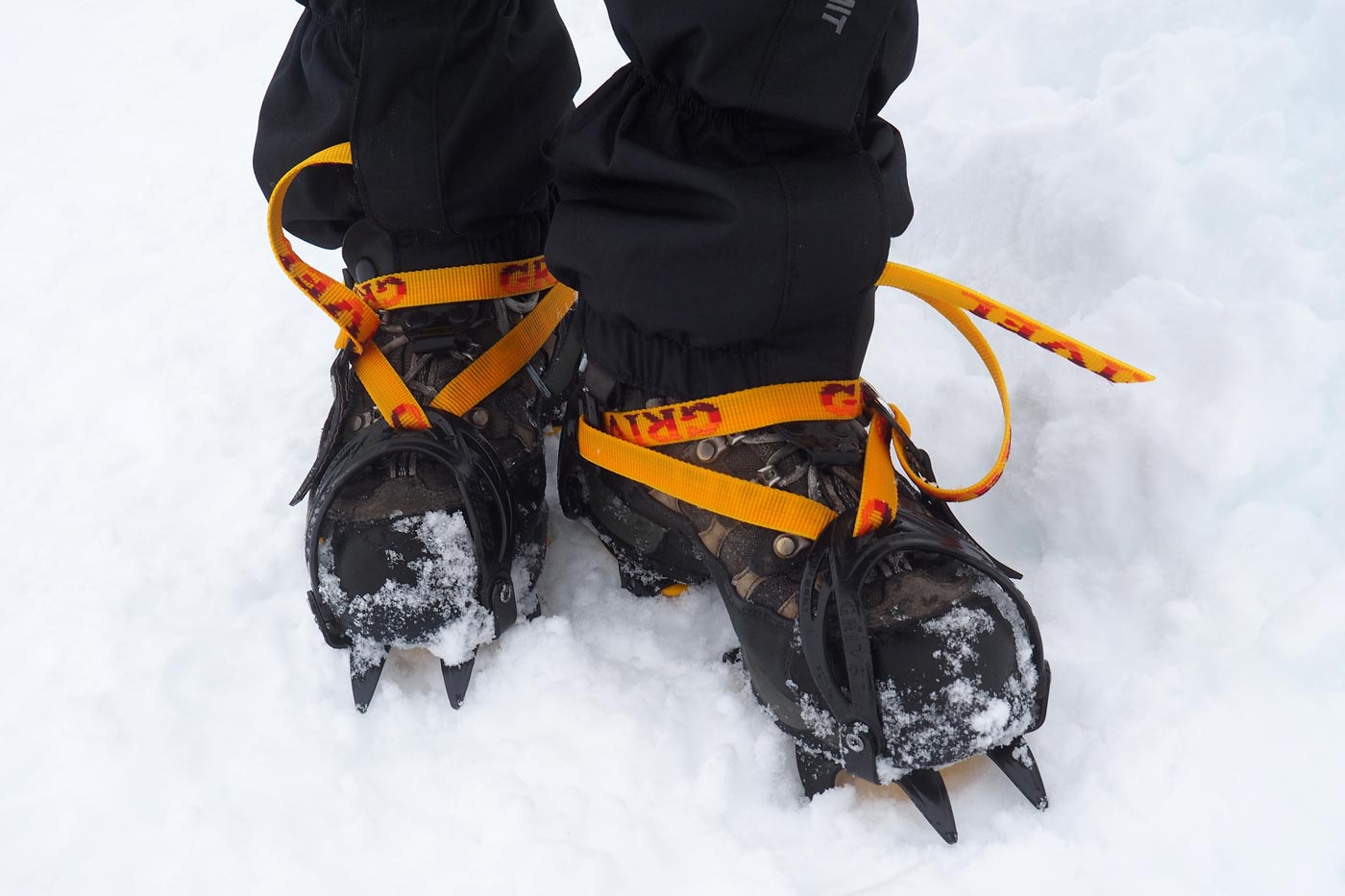 Crampons biting into firm snow to improve grip and stability while walking