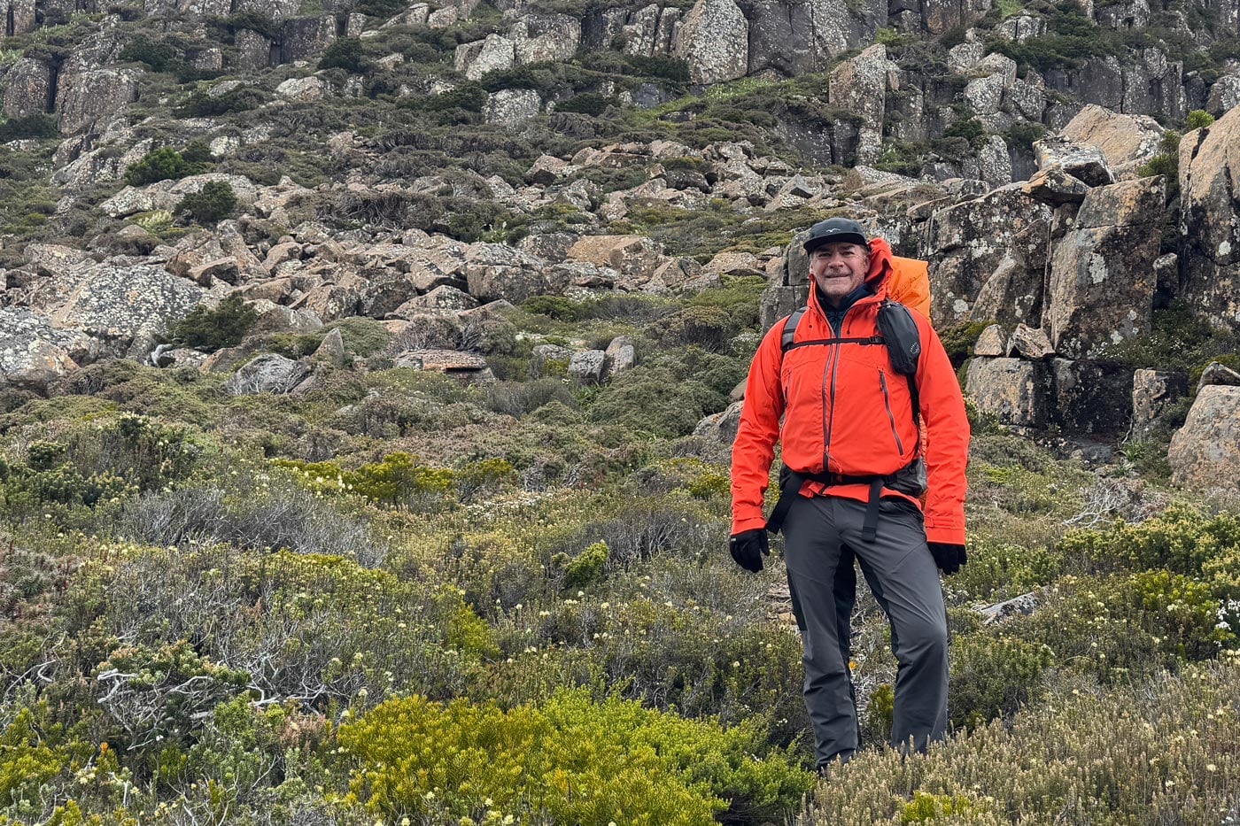 Hiker wearing waterproof shell gloves in wet and windy alpine terrain