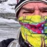 Hiker wearing a buff for wind and cold protection in alpine conditions