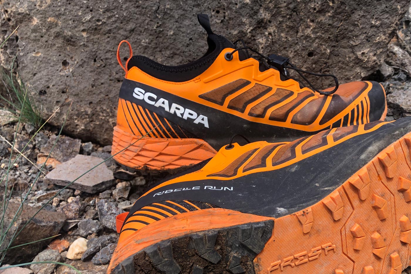 Synthetic fabric hiking shoes with reinforced overlays and mesh panels, showing lightweight construction on rocky terrain.