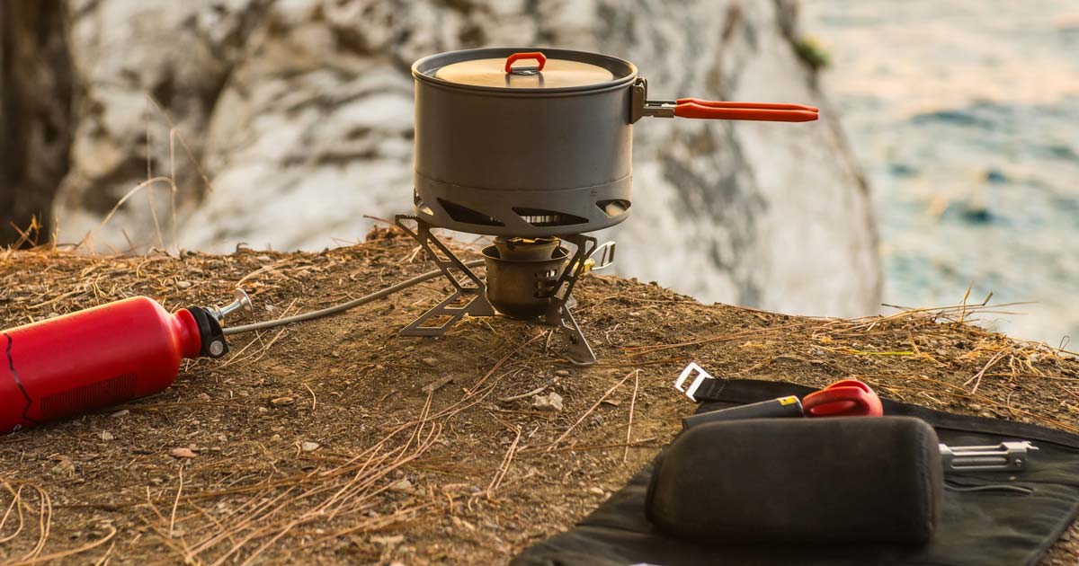 Lightweight hiking stove and cookware set up at a campsite on a multi-day hike
