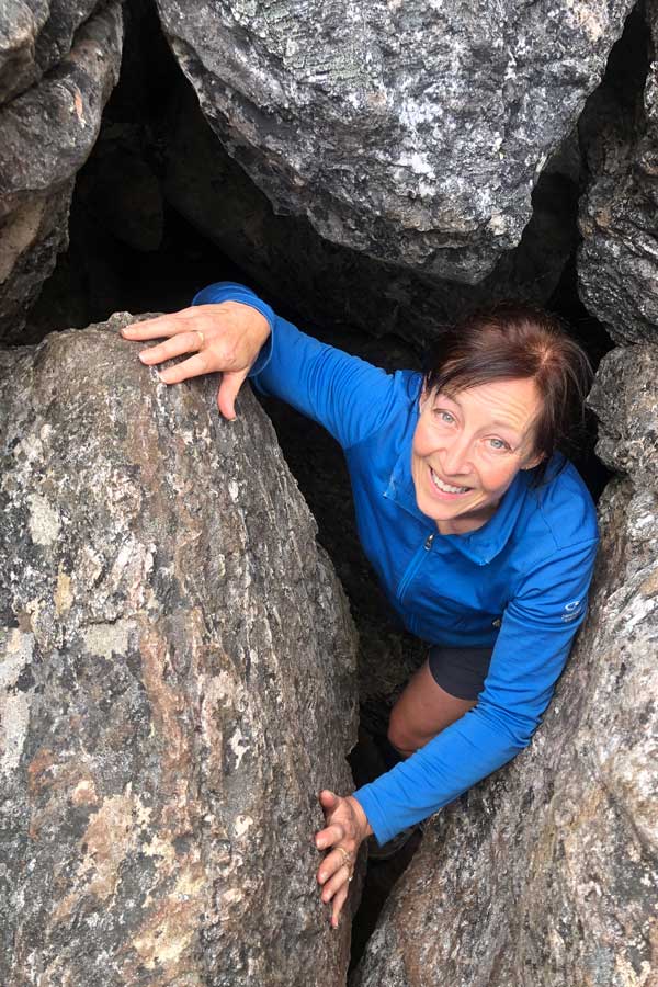 climbing-through-a-boulder-cave Image of julie climbing through a boulder cave
