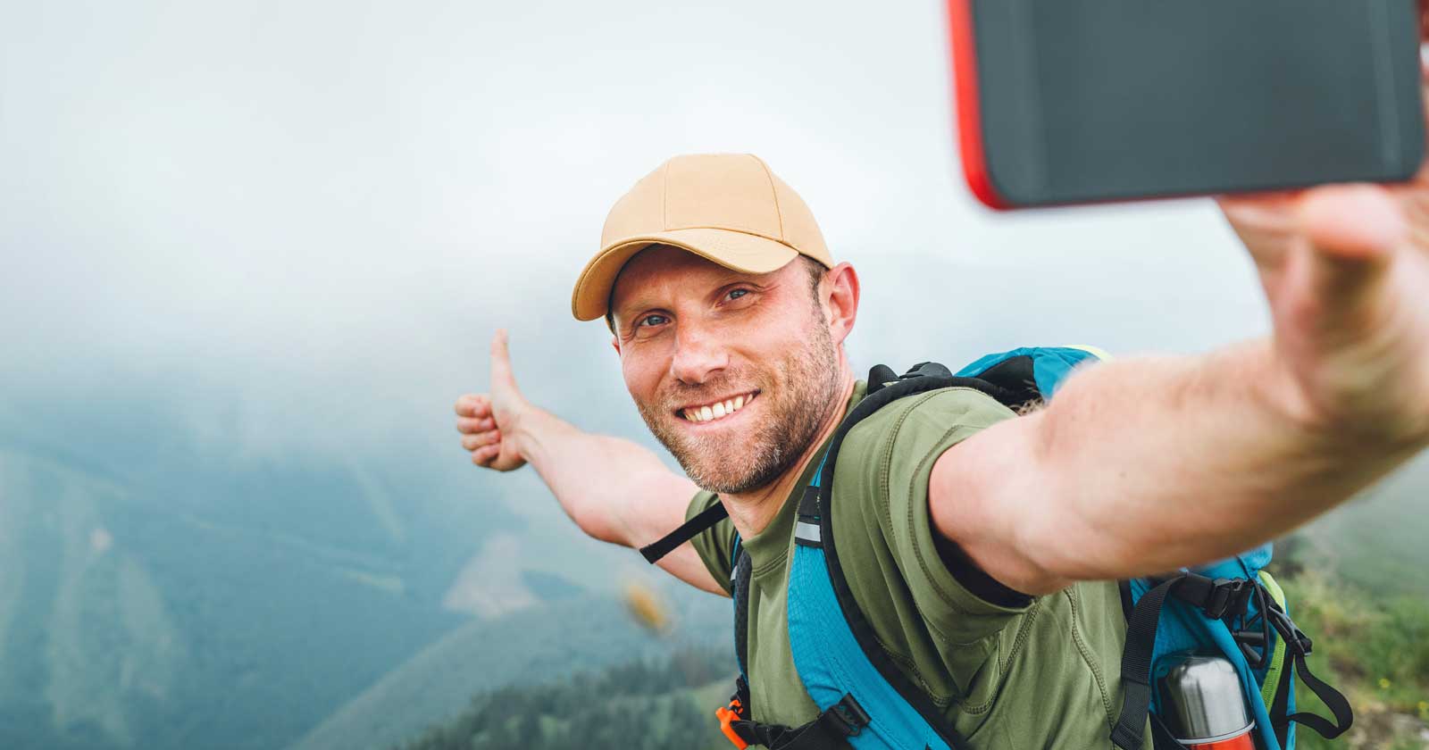Hiker taking selfie with smartphone Hiker taking selfie with smartphone