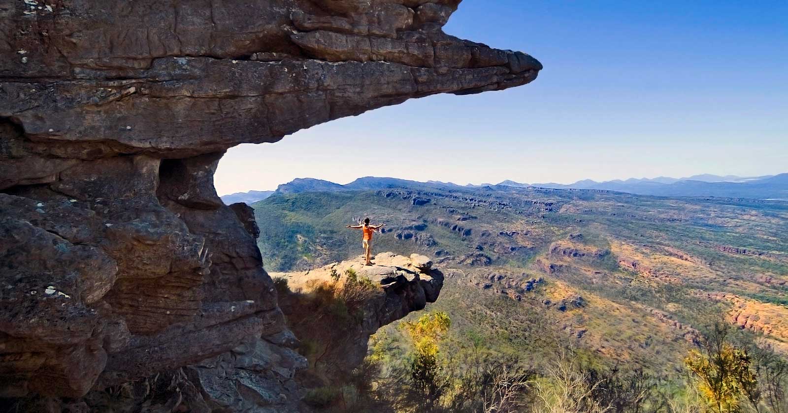 Hikers crossed a safety barrier to take a photo on a dangerous ledge at Grampians National Park. Hiker crossed a safety barrier to take a photo on an exposed ledge at grampians national park.