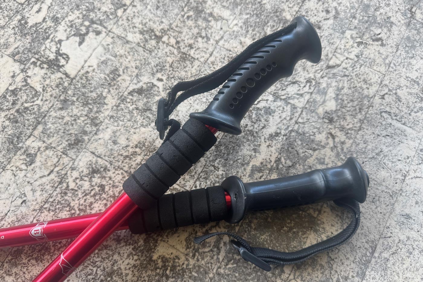 Rubber and dense synthetic hiking pole grips with wrist straps, shown on adjustable poles