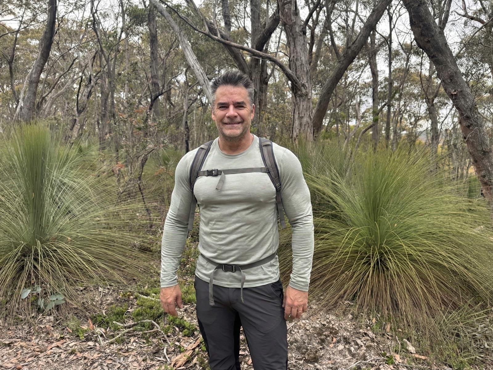 Man wearing the zorali merino ls base layer on a hiking trail.