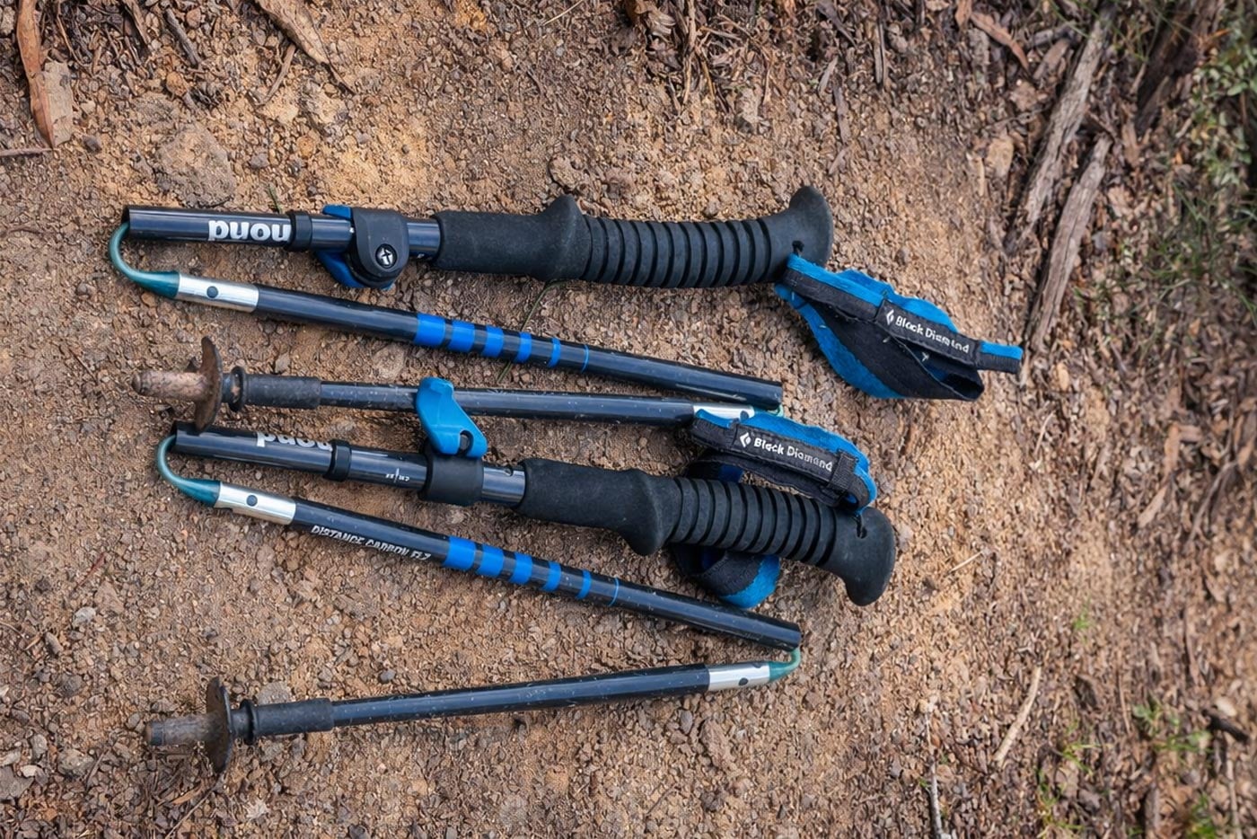 Folding z-style hiking poles collapsed into short sections, showing compact design and internal cord construction