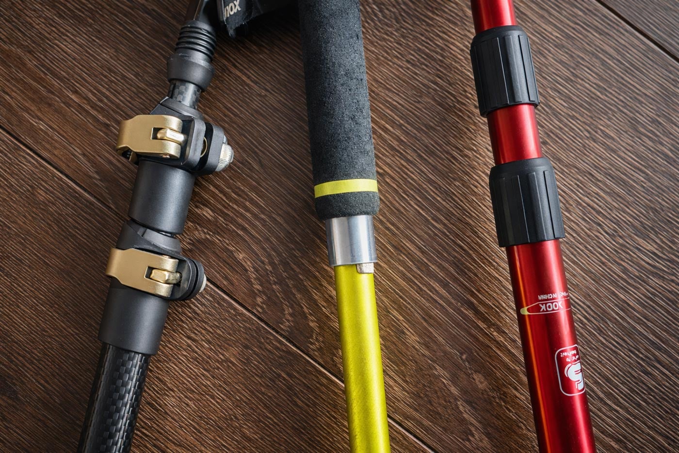 Close-up of hiking poles showing external lever locks, internal twist locks, and push-button snap locks on different pole designs