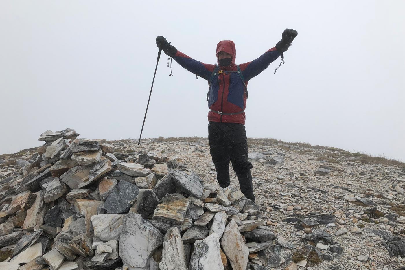 Darren edwards standing on the summit of frenchmans cap in tasmania in cold whiteout conditions
