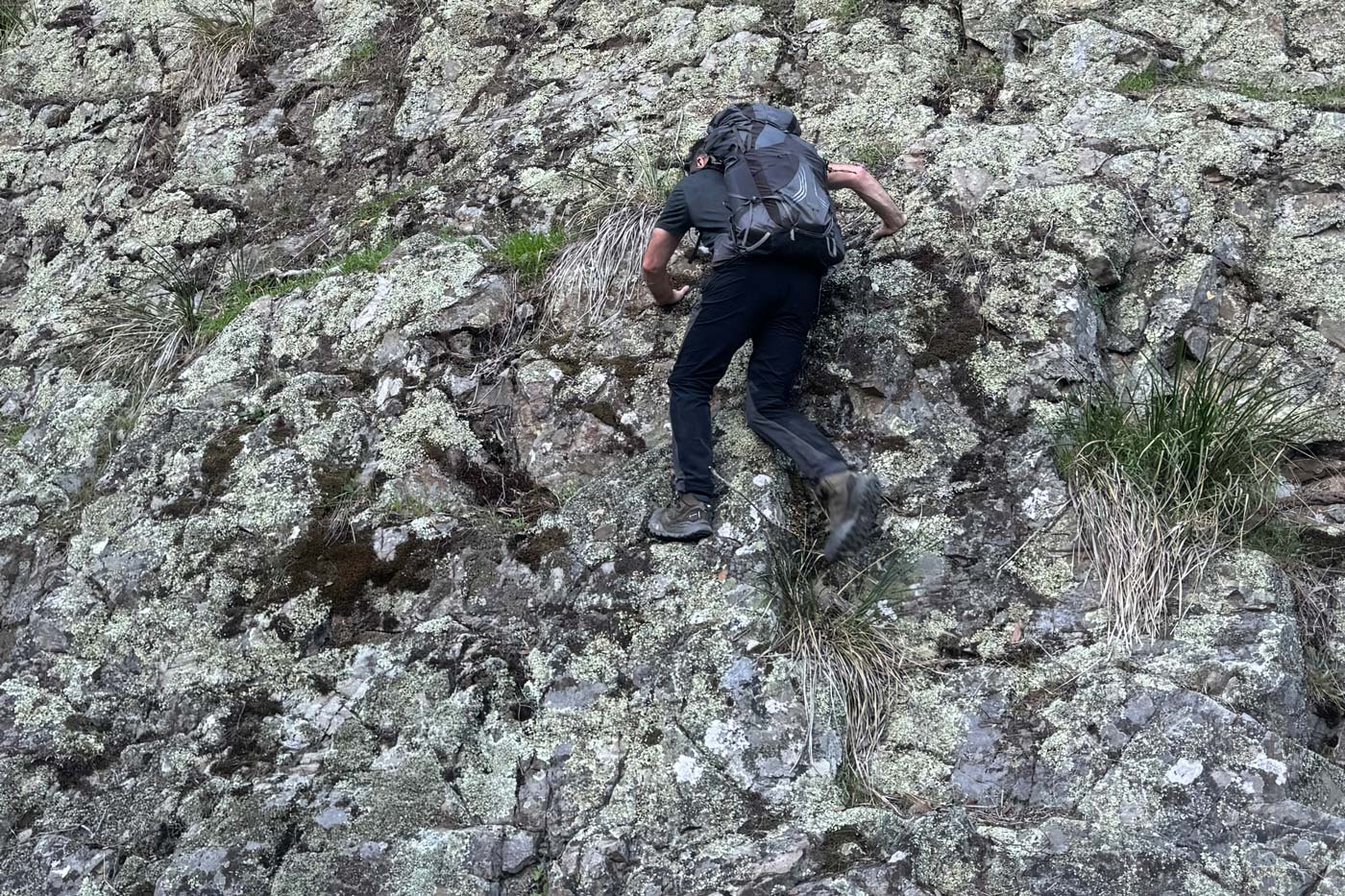 Hiker climbing steep rocky slope wearing the north face offtrail hike lt mid gore-tex boots