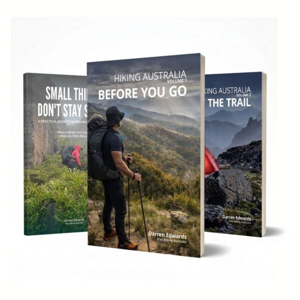 Three hiking books by darren edwards: small things don’t stay small, hiking australia volume 1: before you go, and volume 2: on the trail, displayed against an australian landscape.