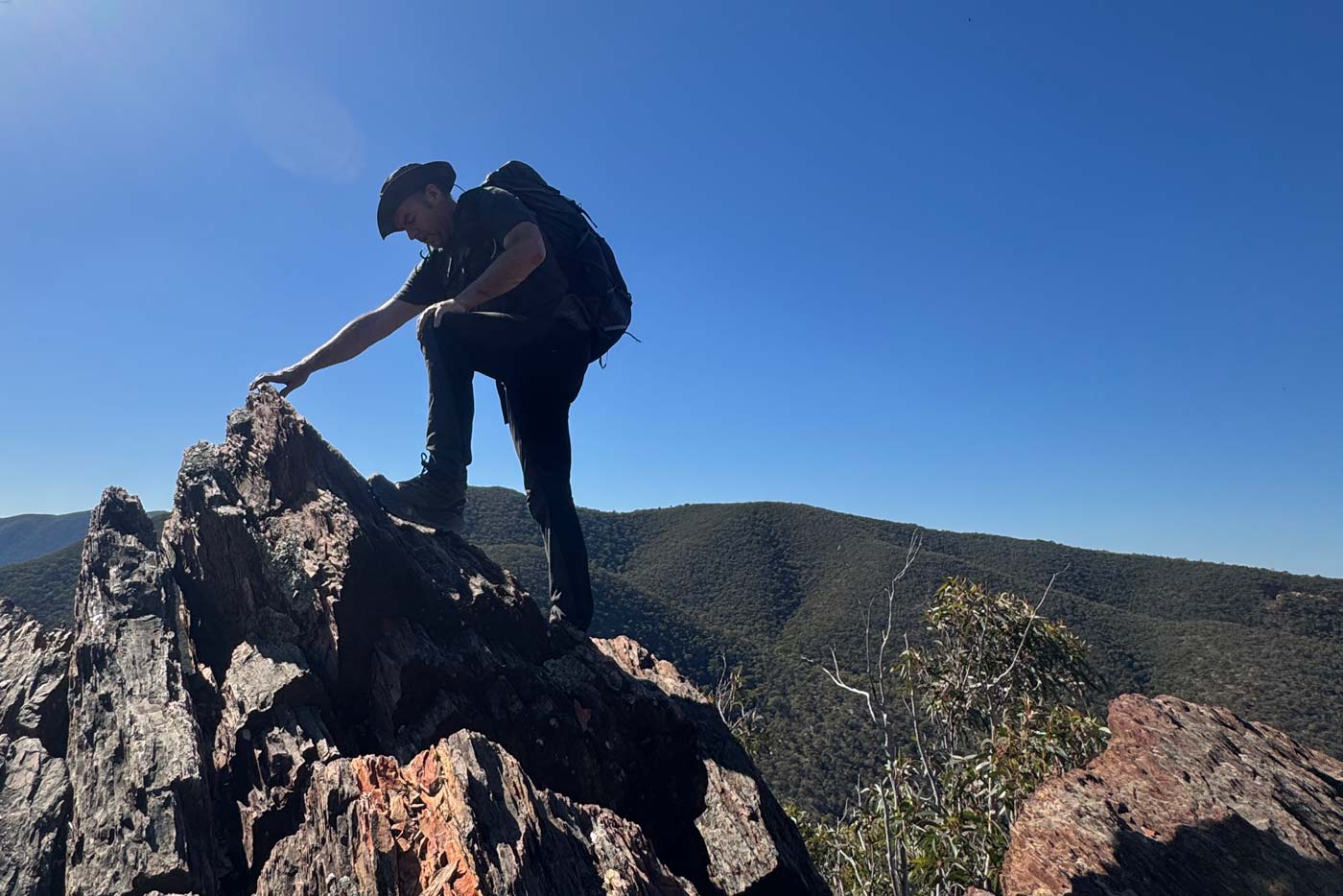 Hiker wearing the north face offtrail hike lt mid gore-tex boots climbing steep rocky outcrop