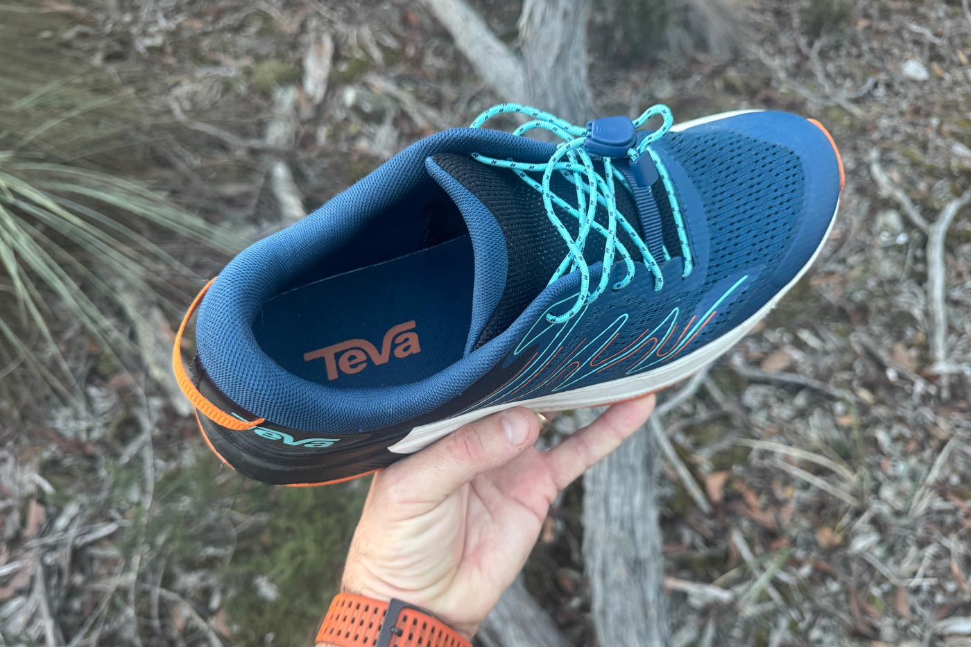 Teva Hurricane Trailsetter Shoe Review Teva hurricane trailsetter held by hand showing mesh upper, heel padding, speed lace toggle and teva branding