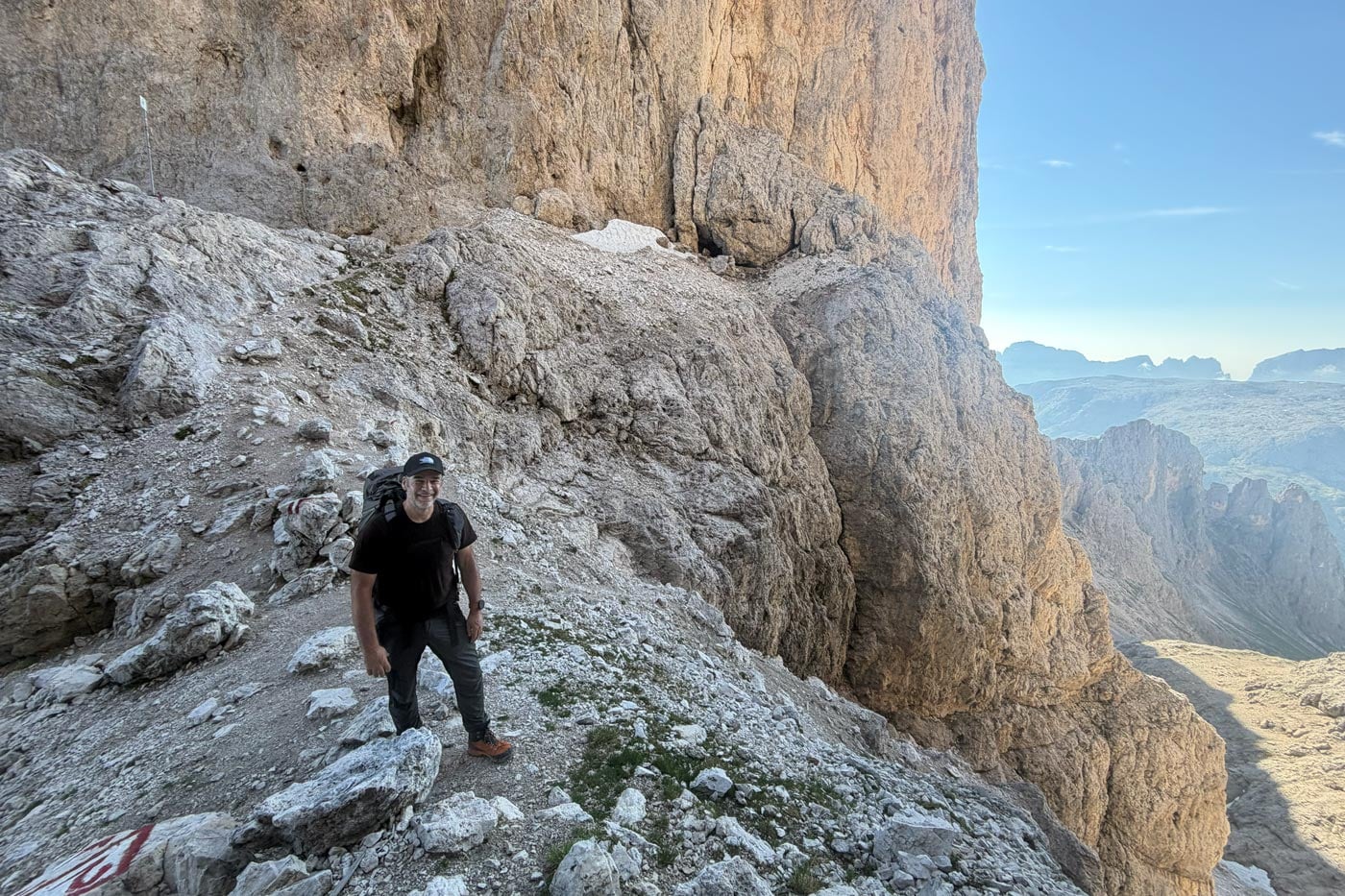 Hiker wearing a snowgum merino 180 merano tee on exposed rocky terrain during the alta via 2 trek in the dolomites
