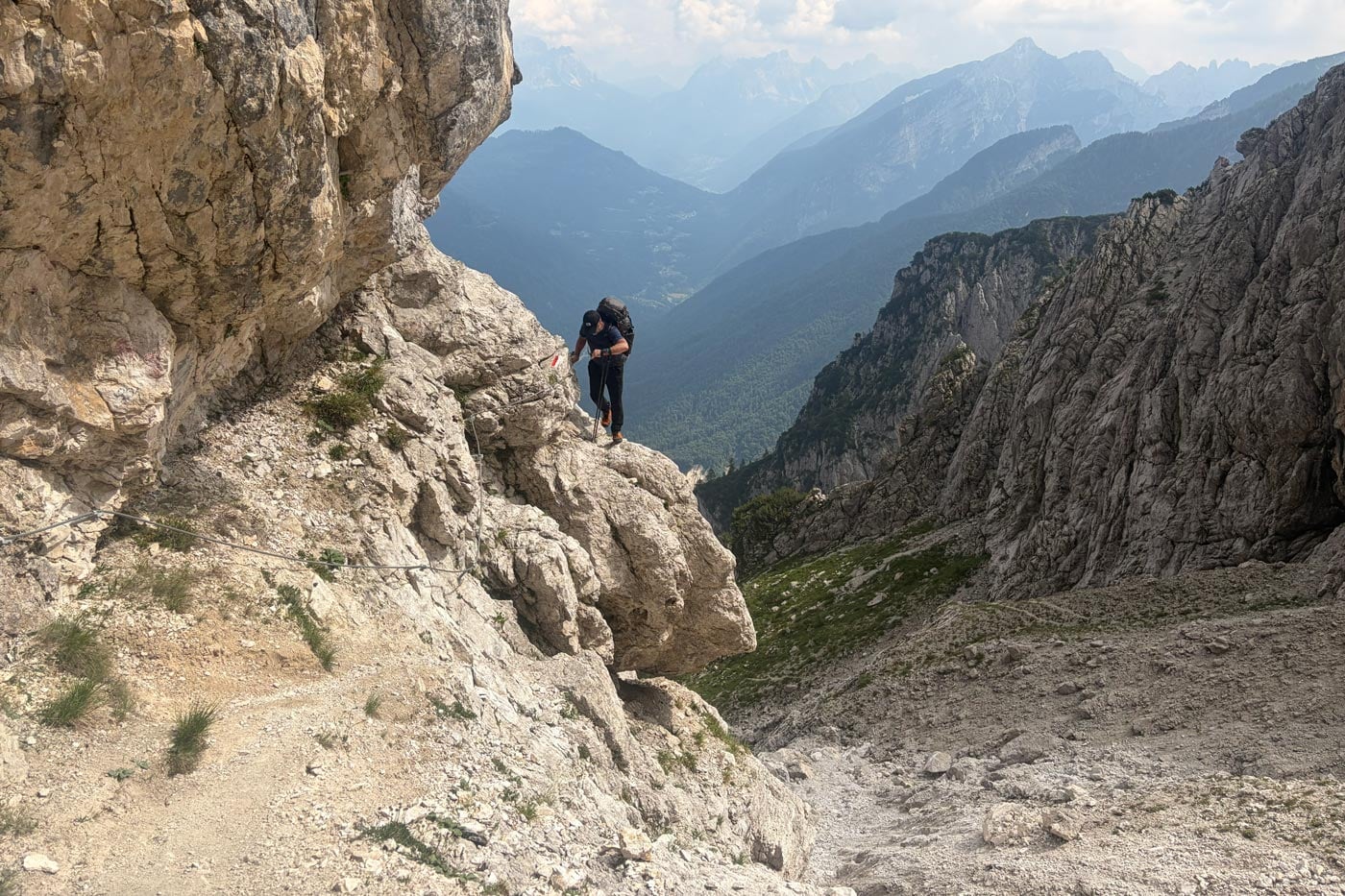 Hiker wearing a snowgum merino 180 merano tee on a technical alpine section of the alta via 2 in the dolomites