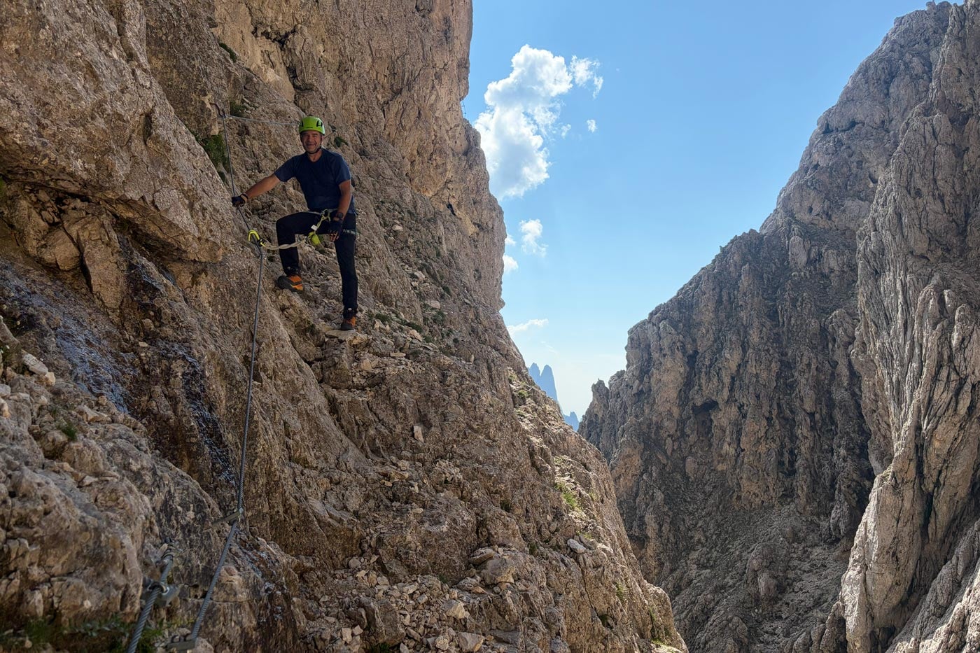 Hiker wearing a snowgum merino 180 merano tee on steep rocky terrain during the alta via 2 trek in the dolomites