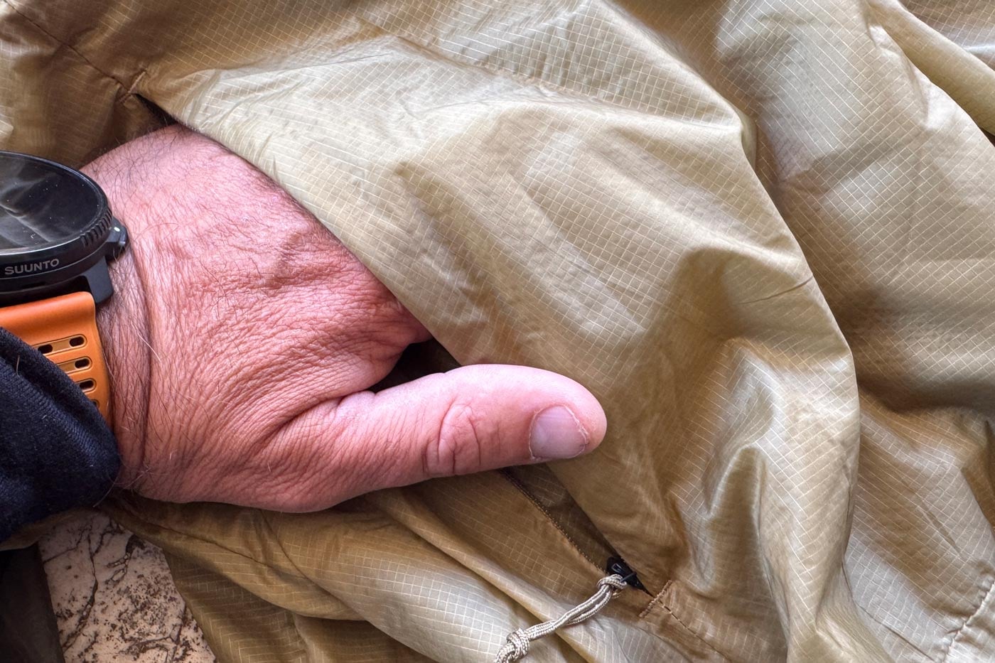 Close-up of a hand accessing the secure-zip pocket on a ridgelite futurefleece wind jacket.