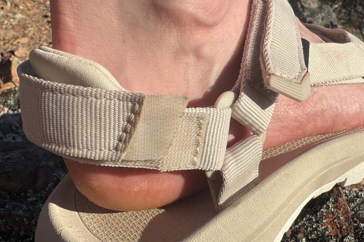 Teva Women's Hurricane XLT3 Sandal Review Close-up of a sandal's webbing strap and buckle system on a foot, showing stitching detail