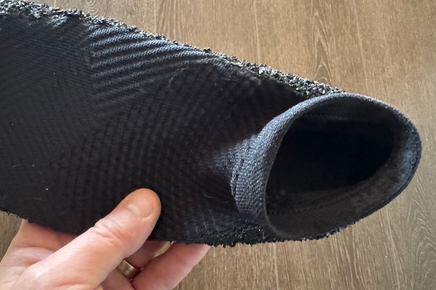 Skinners Comfort 2.0 Sock Shoe Review Hand holding a black tubular fabric section with a frayed, textured edge along one side